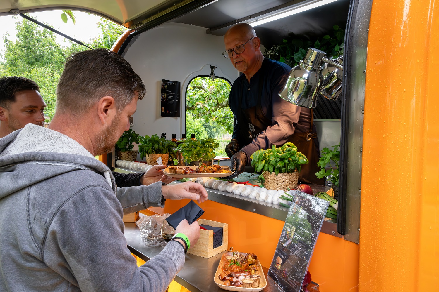 Mensen halen gerechten af bij onze food truck.